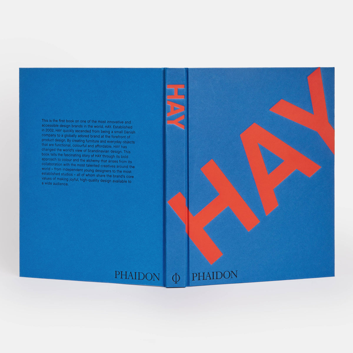 HAY book laid open flat showing the blue front and back covers and spine with red title