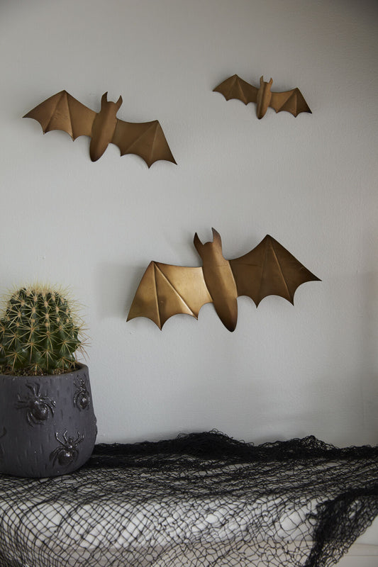 Gold metal bats hung on a wall in a flying cluster