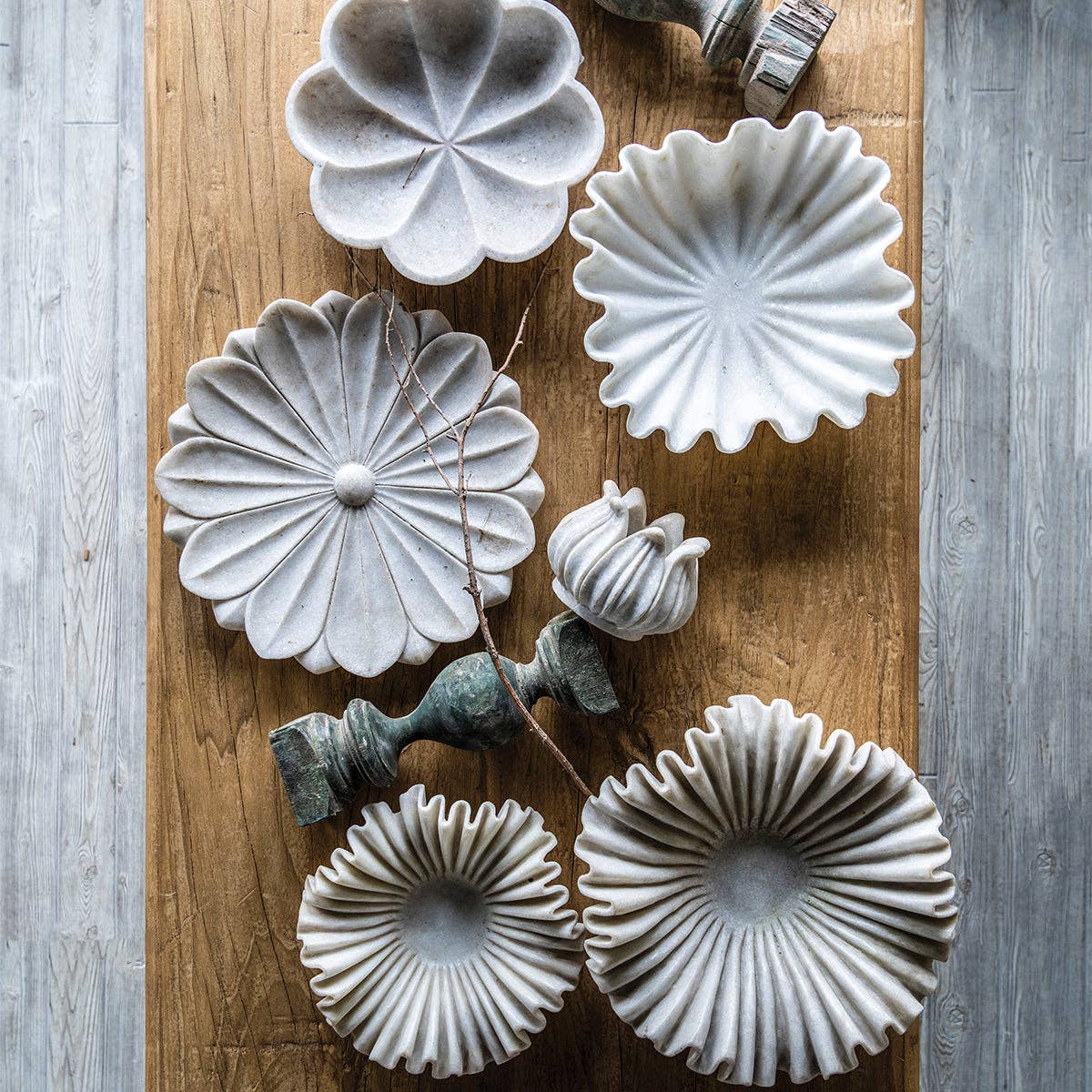 Saxon bowls in two sizes with white marble flower dishes and finials on a rustic wood table
