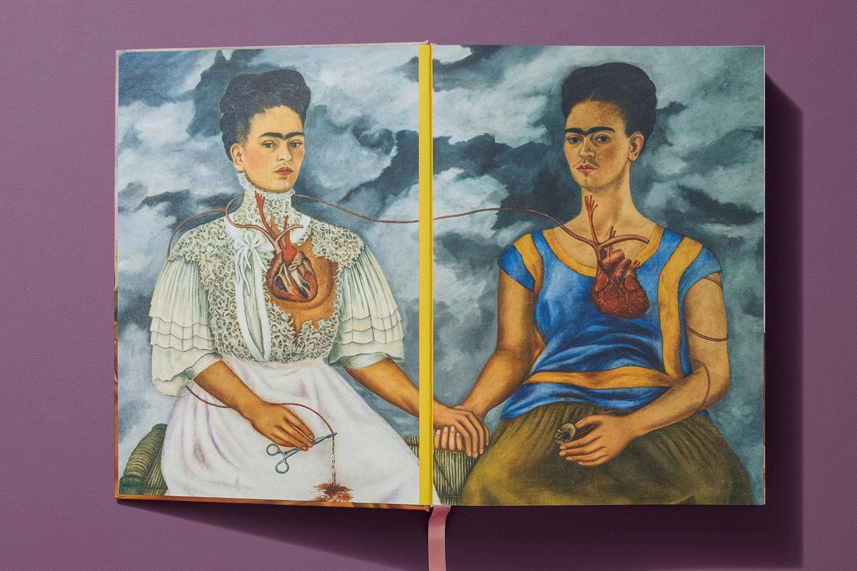 Open Frida Kahlo book spread showing The Two Fridas painting, two seated women holding hands