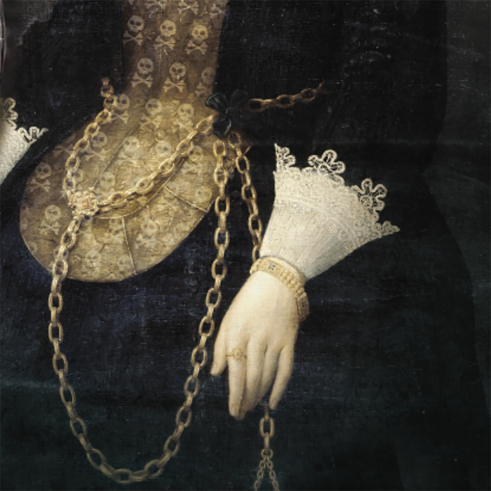 Close-up of the tray's gold skull-pattern bodice, chain necklace and lace cuff on the gloved hand