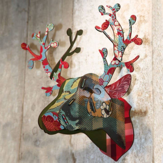 Foliage deer head mounted on a pale wood wall, angled view showing its layered pieces