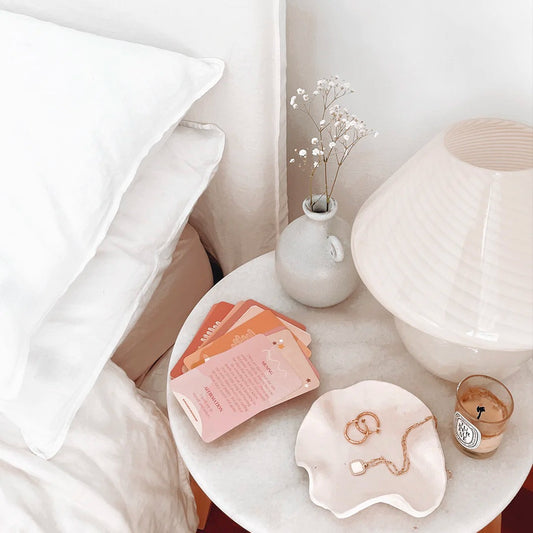 sample cards on nightstand table with home decor, lamp, and next to a bed