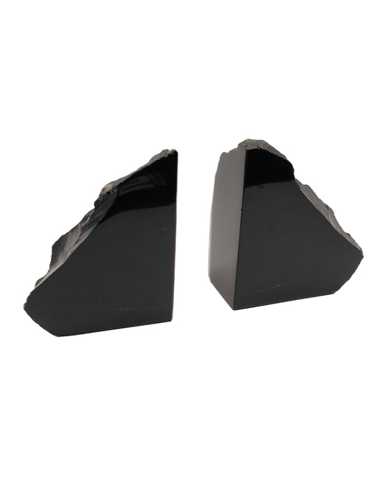 Closer view of the two black obsidian bookends showing smooth polished sides and raw stone tops