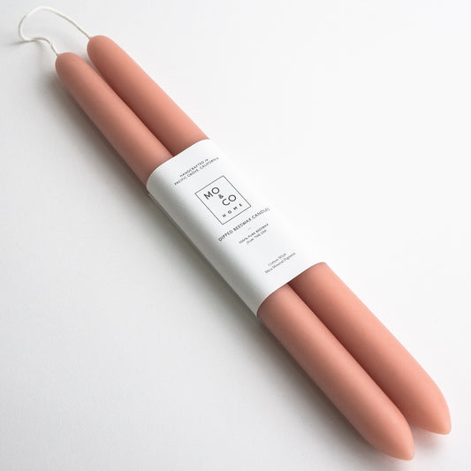 Pair of terra cotta dipped beeswax taper candles joined at the wick, wrapped in a white Mo & Co label