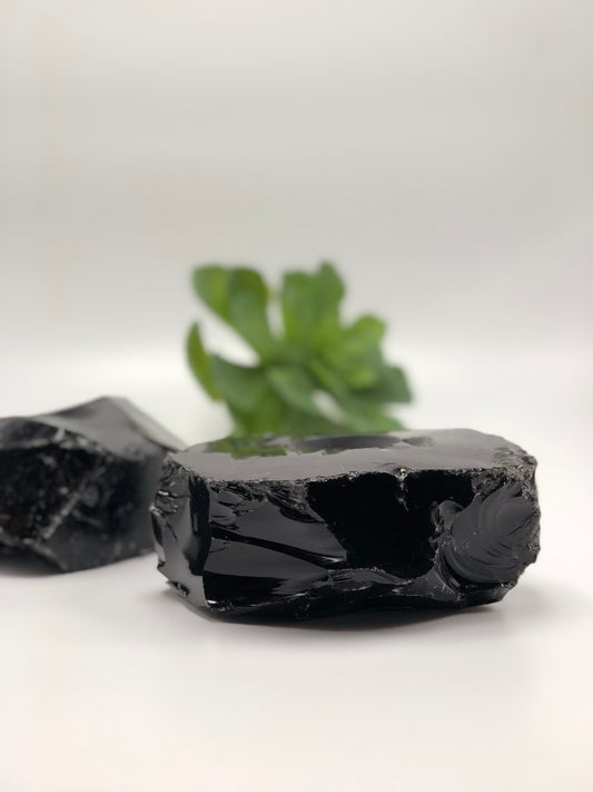Tall view of the obsidian votive holder showing its polished top edge, with a second holder behind
