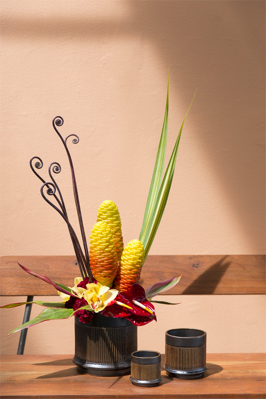 Westcott pots styled with a tropical arrangement of ginger and anthurium on a wood bench