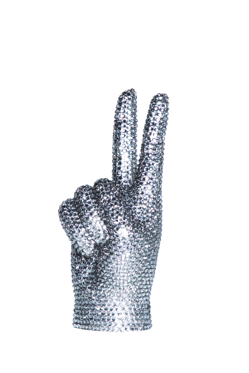 Back of the rhinestone peace sign hand showing folded fingers and thumb covered in gray crystals