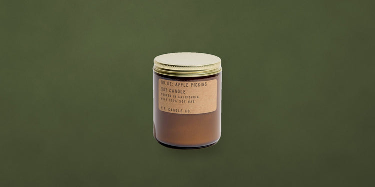 Apple Picking soy candle in amber jar on a moss green backdrop - Onederkam holiday