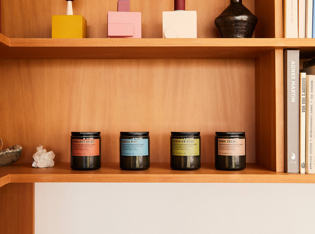 Myrtle Mint candle lined up with three other Alchemy candles on a wooden shelf