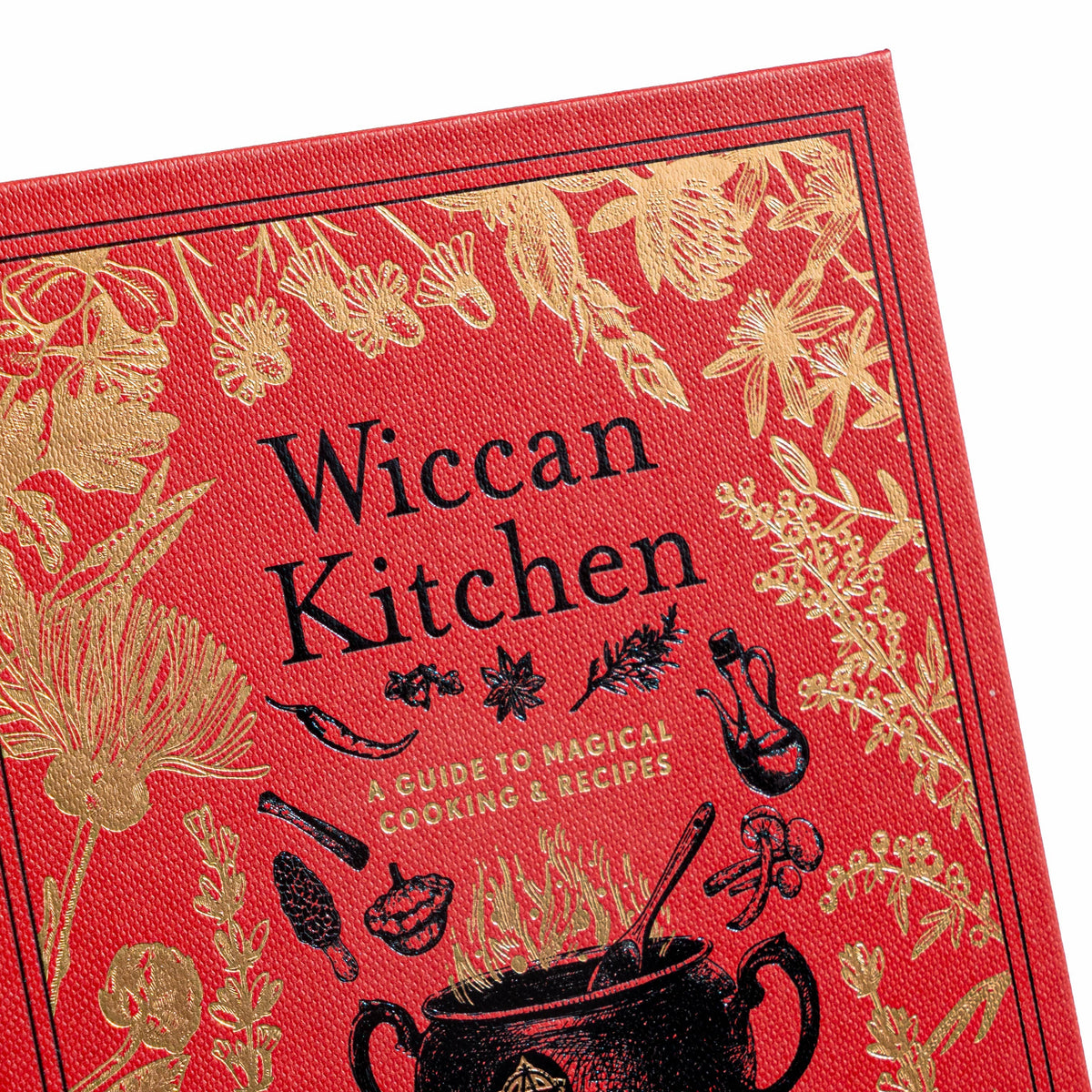 Close-up of the Wiccan Kitchen cover corner showing gold foil herbs and black title