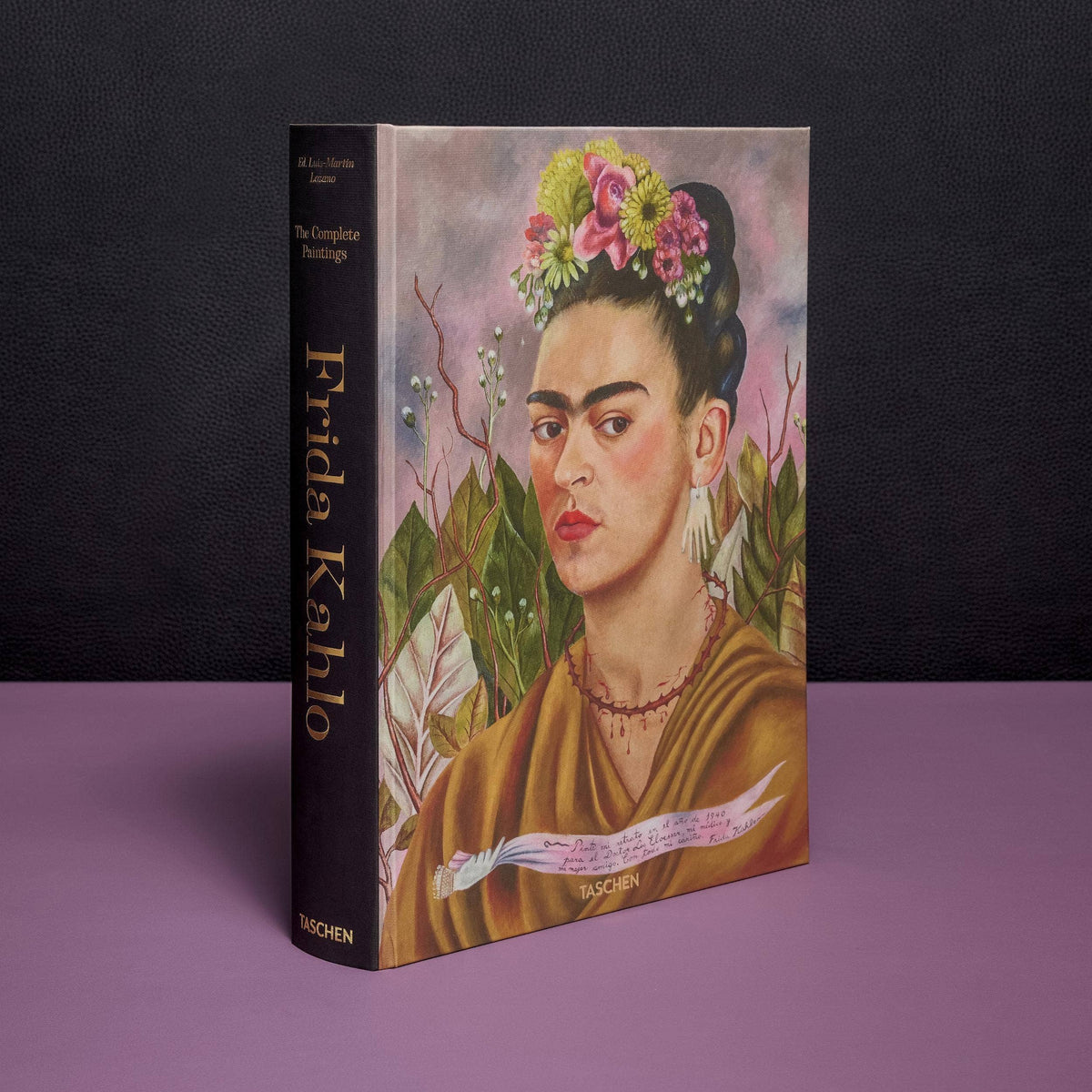 Frida Kahlo The Complete Paintings standing upright, showing its thick black spine with gold title