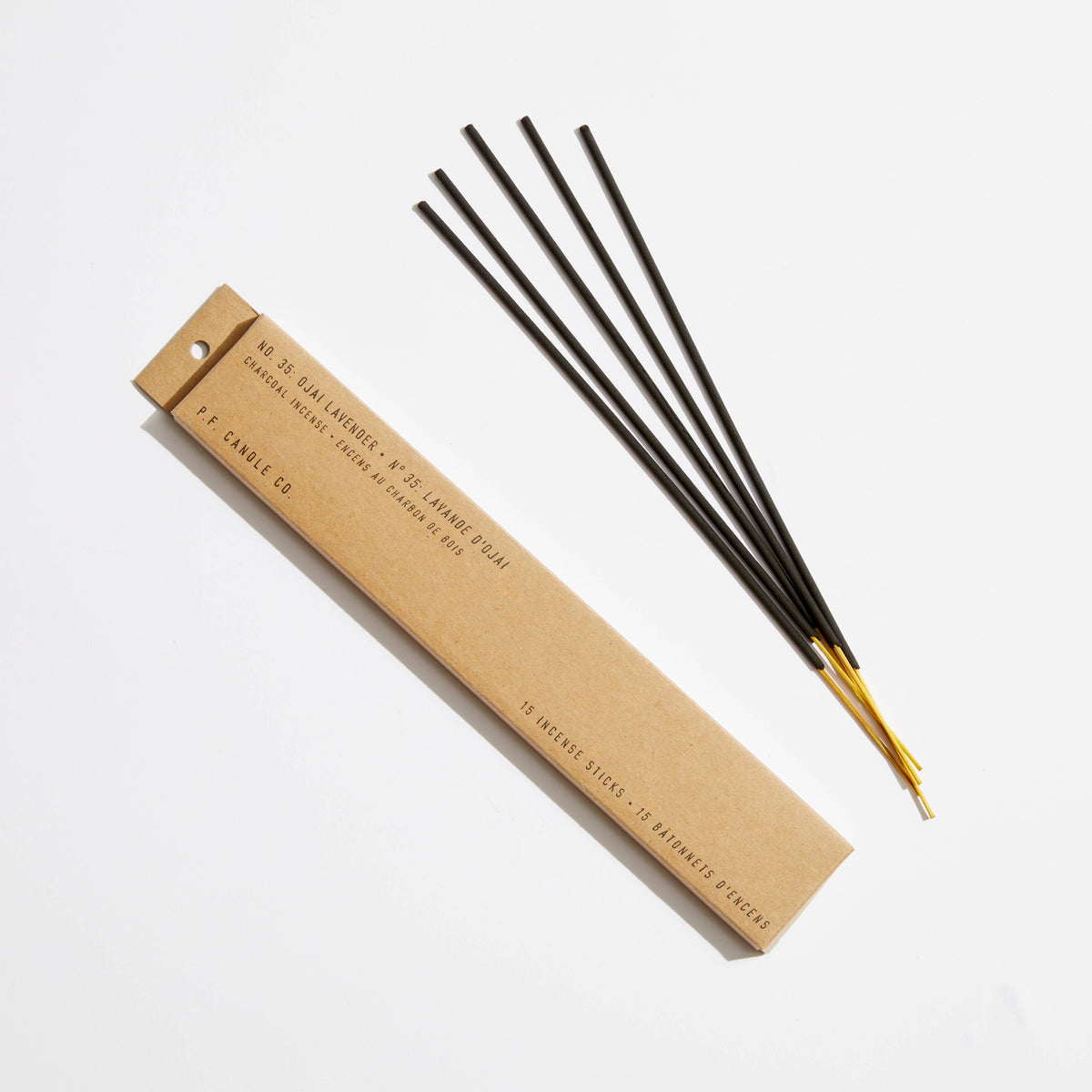 Ojai Lavender incense, five black sticks with gold tips beside a kraft paper box