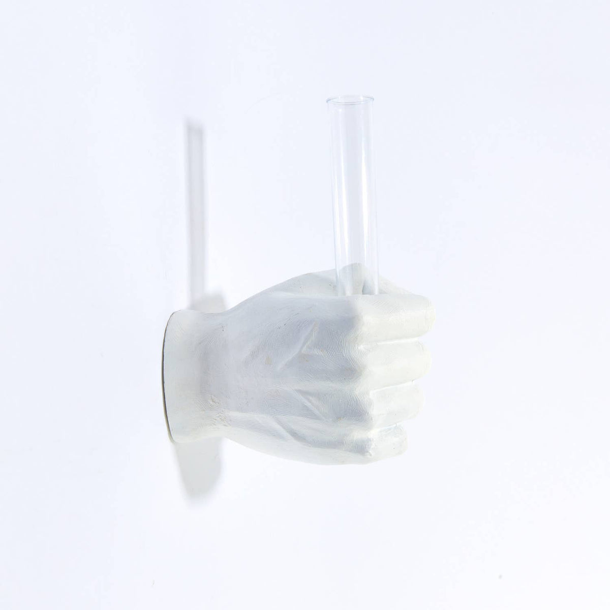 White vase hand wall mount with an empty clear glass tube, facing right
