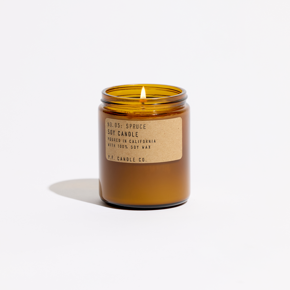 Amber glass candle with a label on a white background