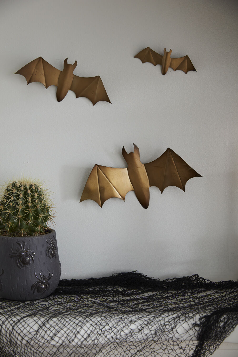 Gold metal bats hung on a wall in a flying cluster