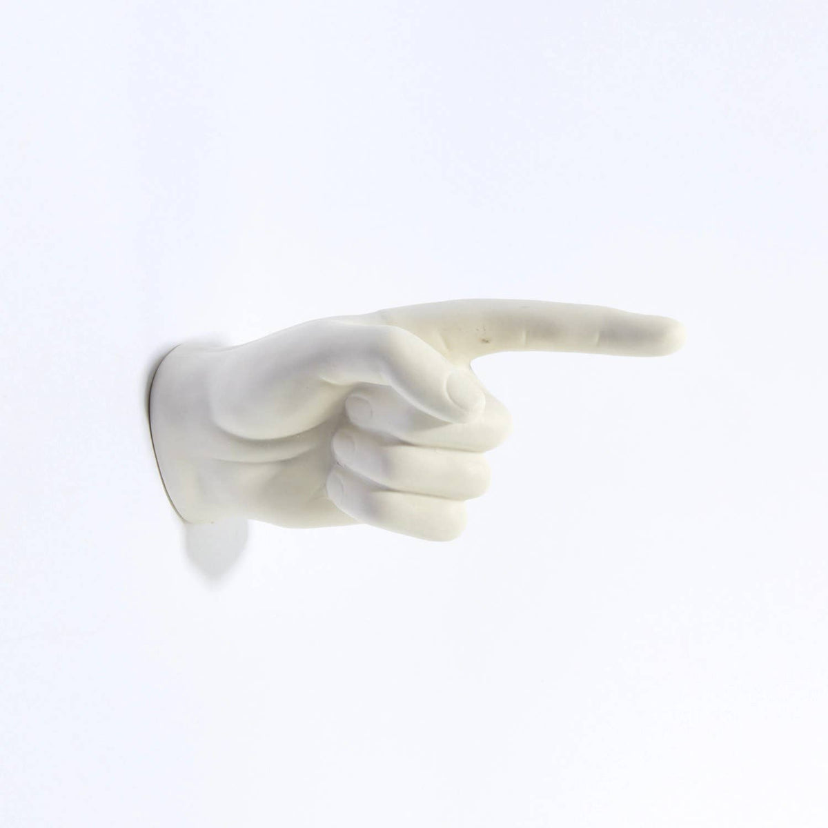 White pointing hand wall hook shown empty from the side, finger pointing right
