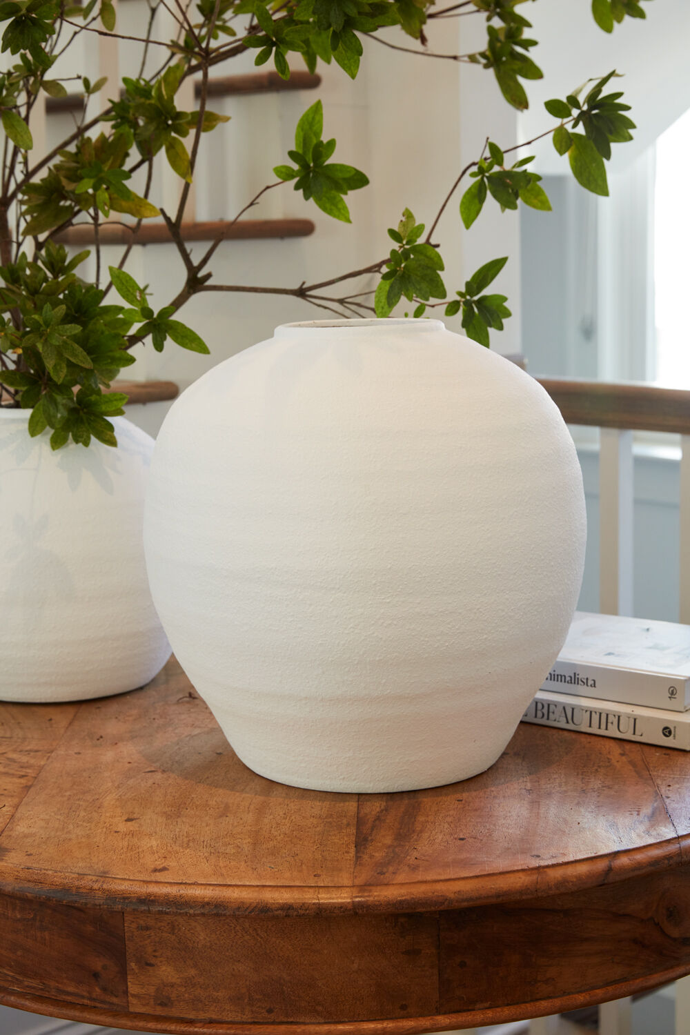 Konos white cement vase with a floral arrangement