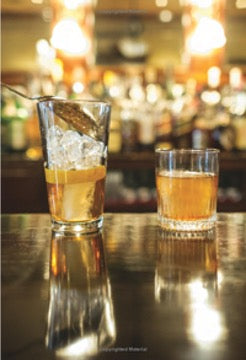 Two old-fashioned cocktails in rocks glasses on a reflective bar, photo from the book