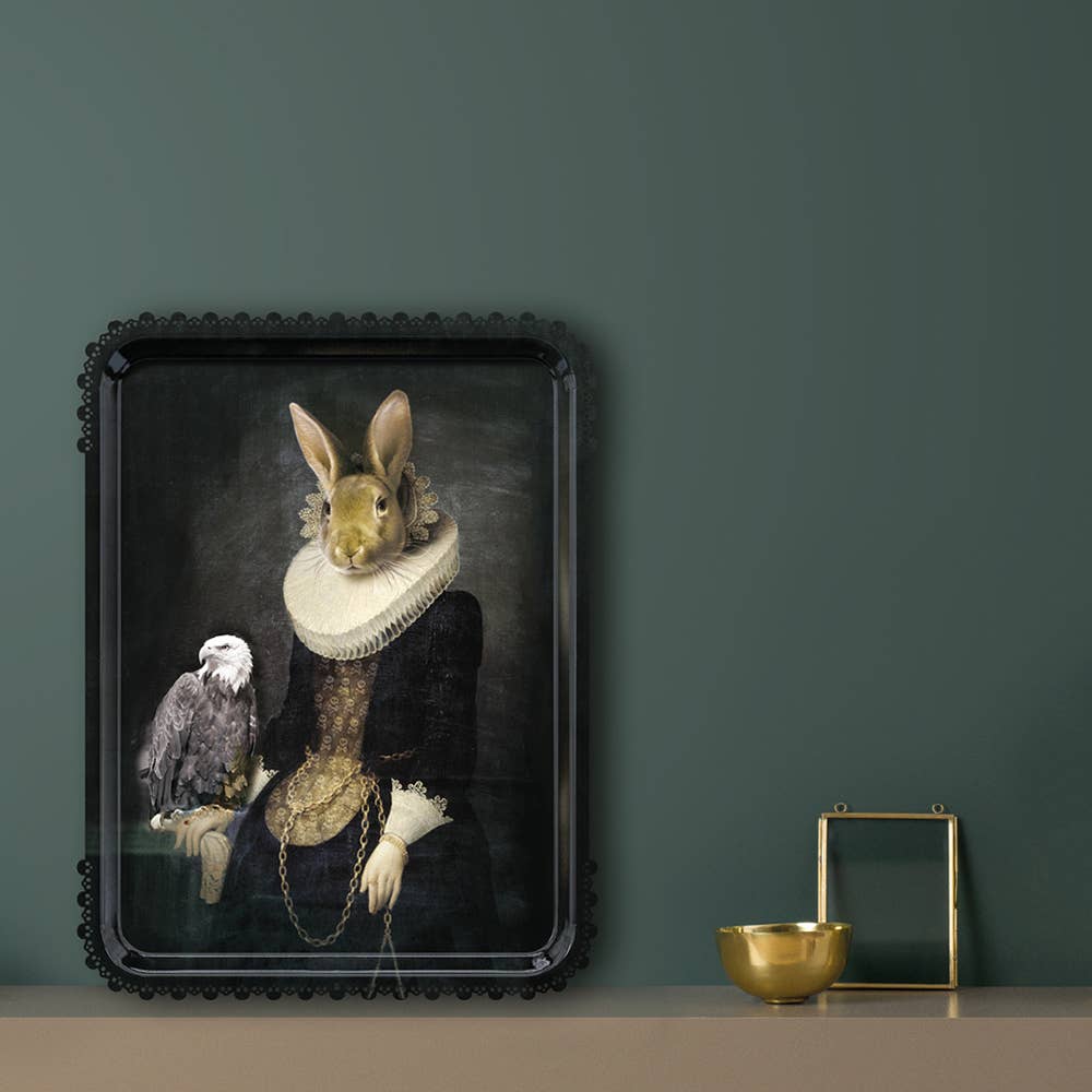 Zhao tray leaning on a shelf against a dark green wall beside a gold bowl and brass frame