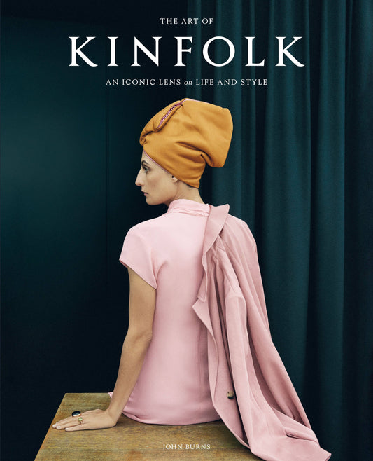 Full front cover of The Art of Kinfolk, An iconic lens on life and style, with a dark teal curtain backdrop