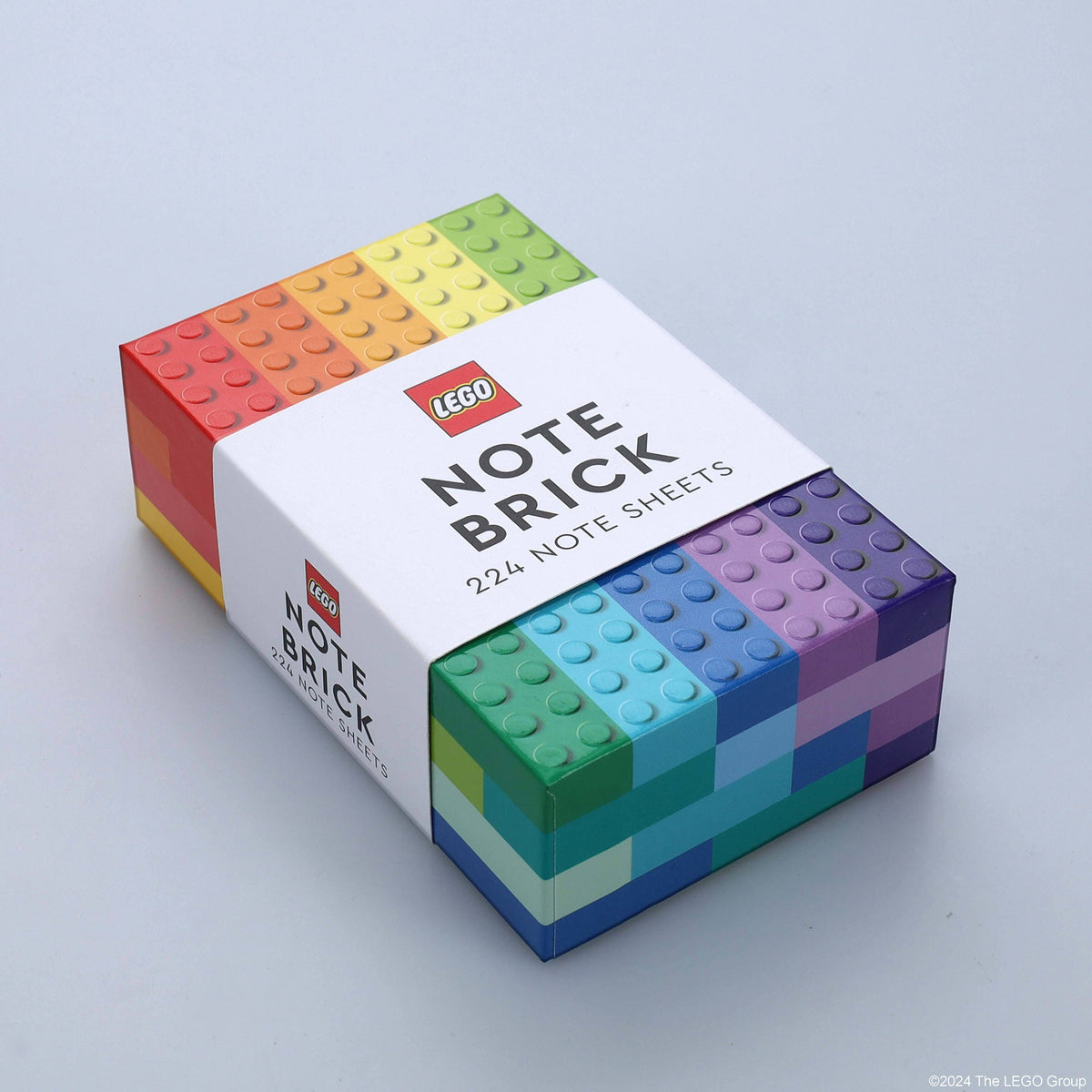 LEGO Note Brick box lying at an angle on gray, sides printed with rainbow brick studs