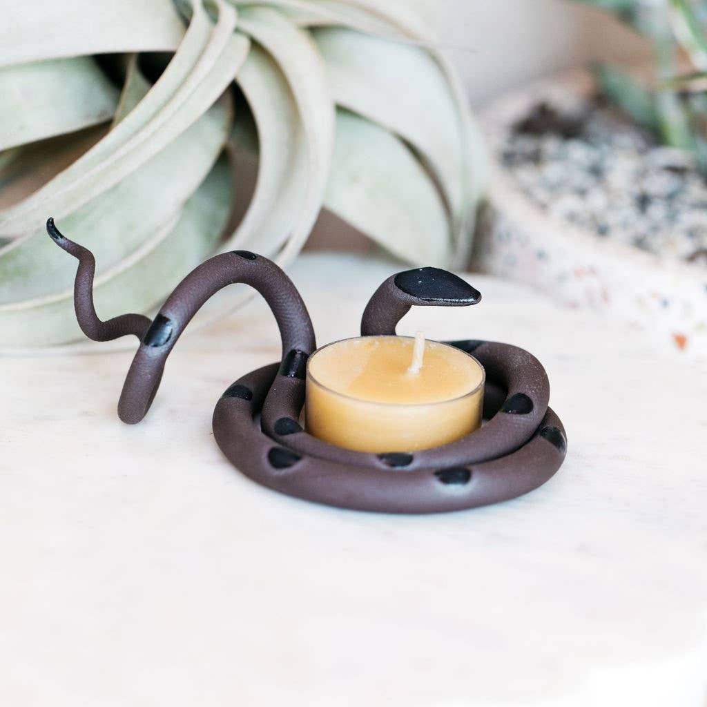 Dark brown ceramic snake tealight holder with black spots and a black head coiled around a beeswax tealight