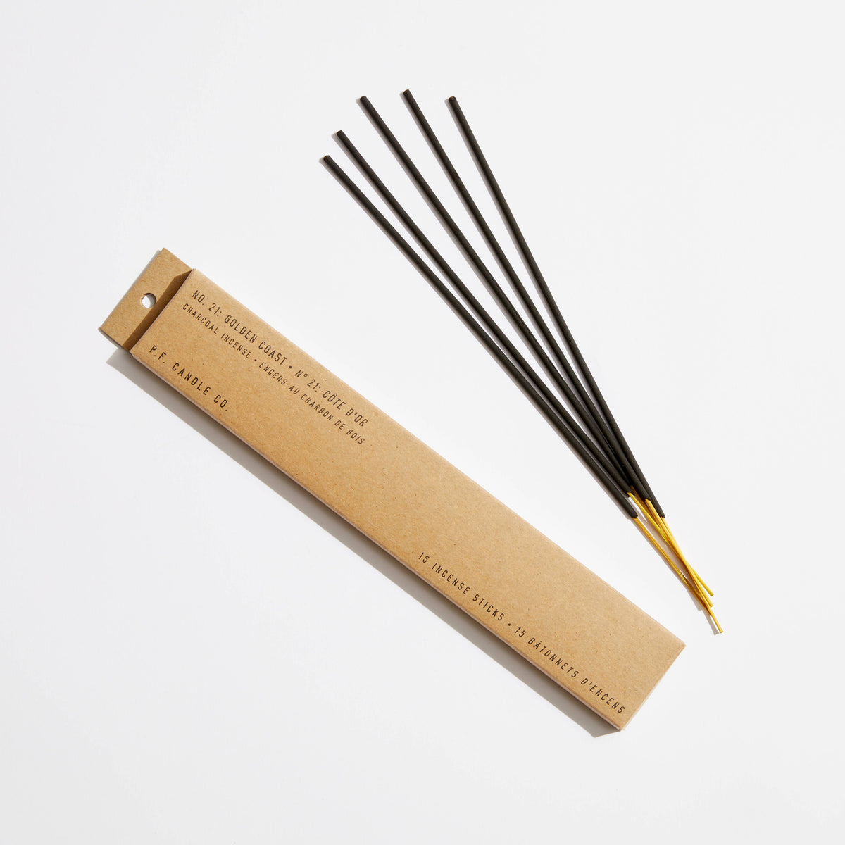 Golden Coast incense: kraft box of 15 charcoal incense sticks beside five black sticks with gold-tipped ends