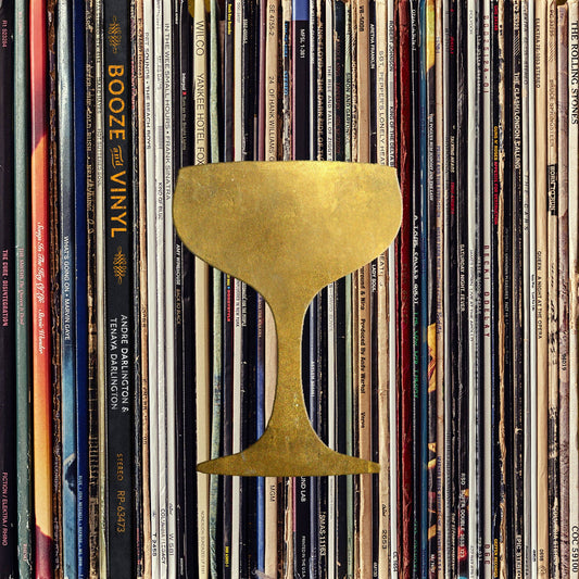 Booze & Vinyl book cover with a gold coupe glass over a wall of record album spines
