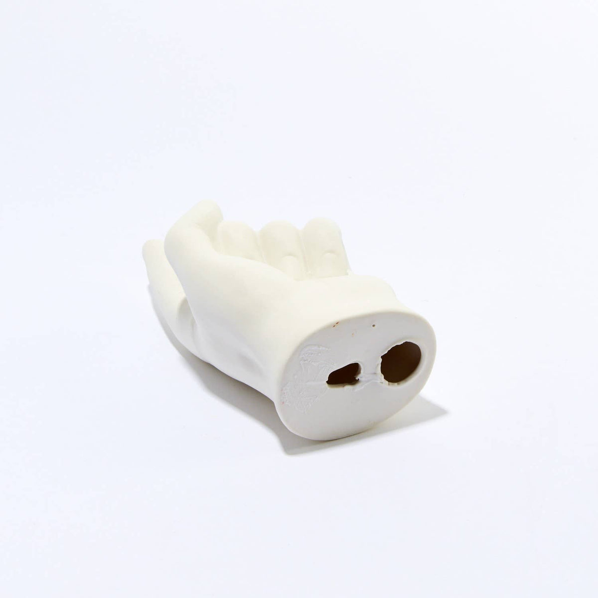 Underside of the white hand hook showing its flat back with two mounting holes