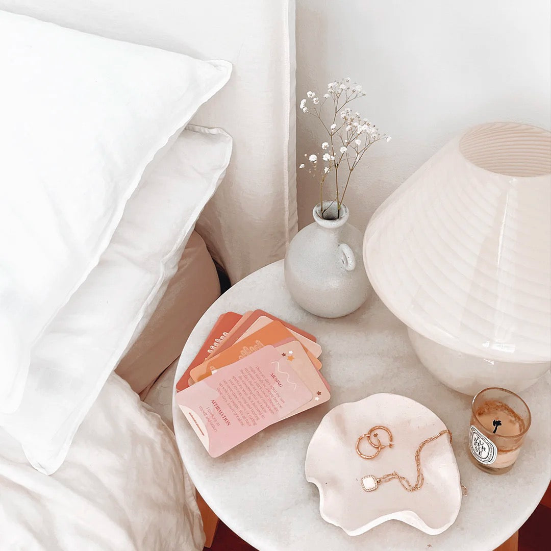 sample cards on nightstand table with home decor, lamp, and next to a bed