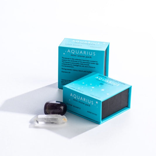 Aquarius mini stone pack text on two blue boxes with Aquarius constellation pattern. Clear quartz and polished amethyst stones in front. 