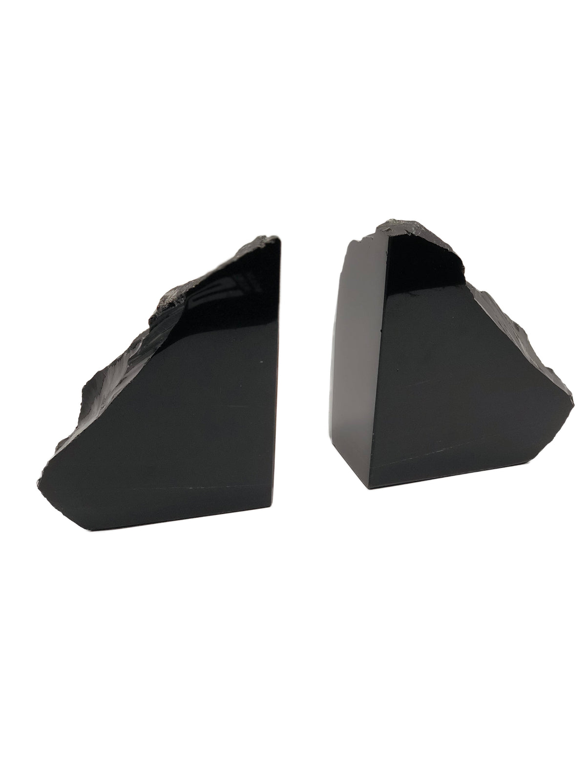 Closer view of the two black obsidian bookends showing smooth polished sides and raw stone tops