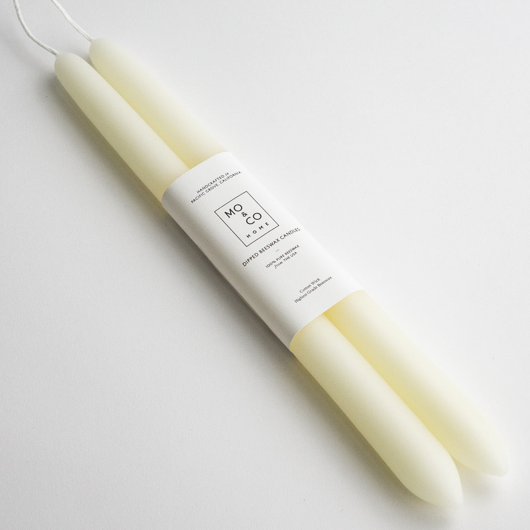 Pair of natural white dipped beeswax taper candles joined at the wick, wrapped in a Mo & Co Home label
