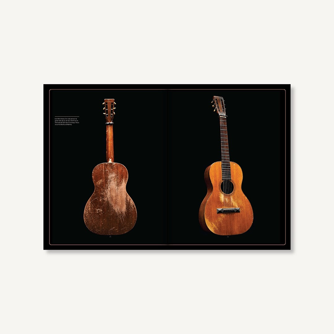Inside spread of Dolly Parton Songteller showing the back and front of a worn acoustic guitar on black pages