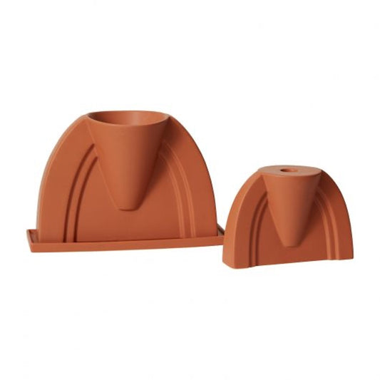 Two DEV pieces in terracotta orange: an arched planter with saucer and a smaller matching candle holder