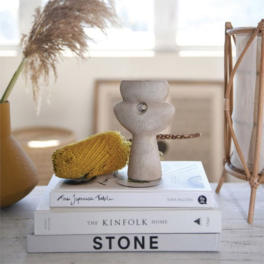 sculptural vase in natural sand color.  Small hole in center on top of books and other decor items