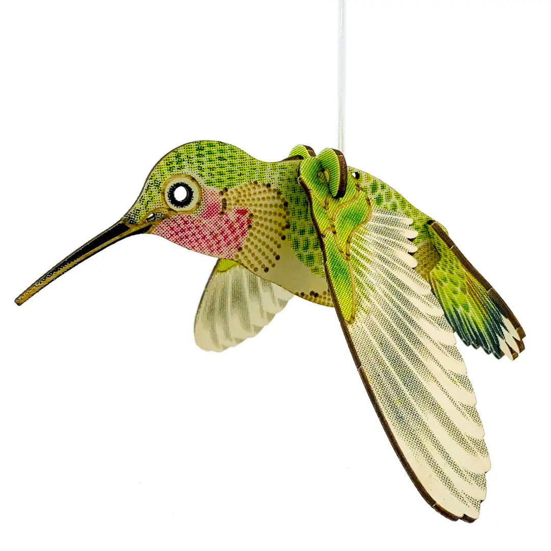 Hummingbird model seen from the side with wings swept down, showing printed feather detail on birch wood