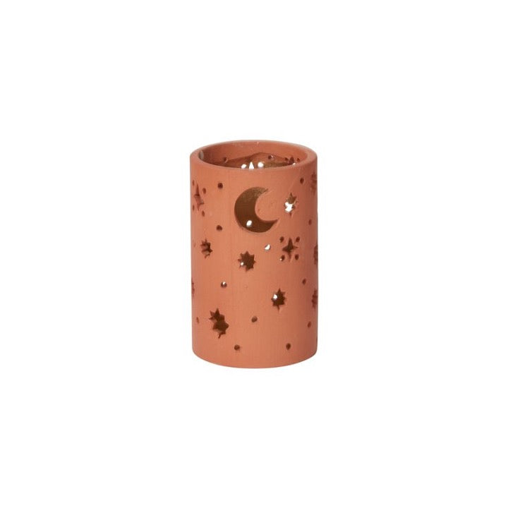 Ceramic votive with cutout moon and stars.