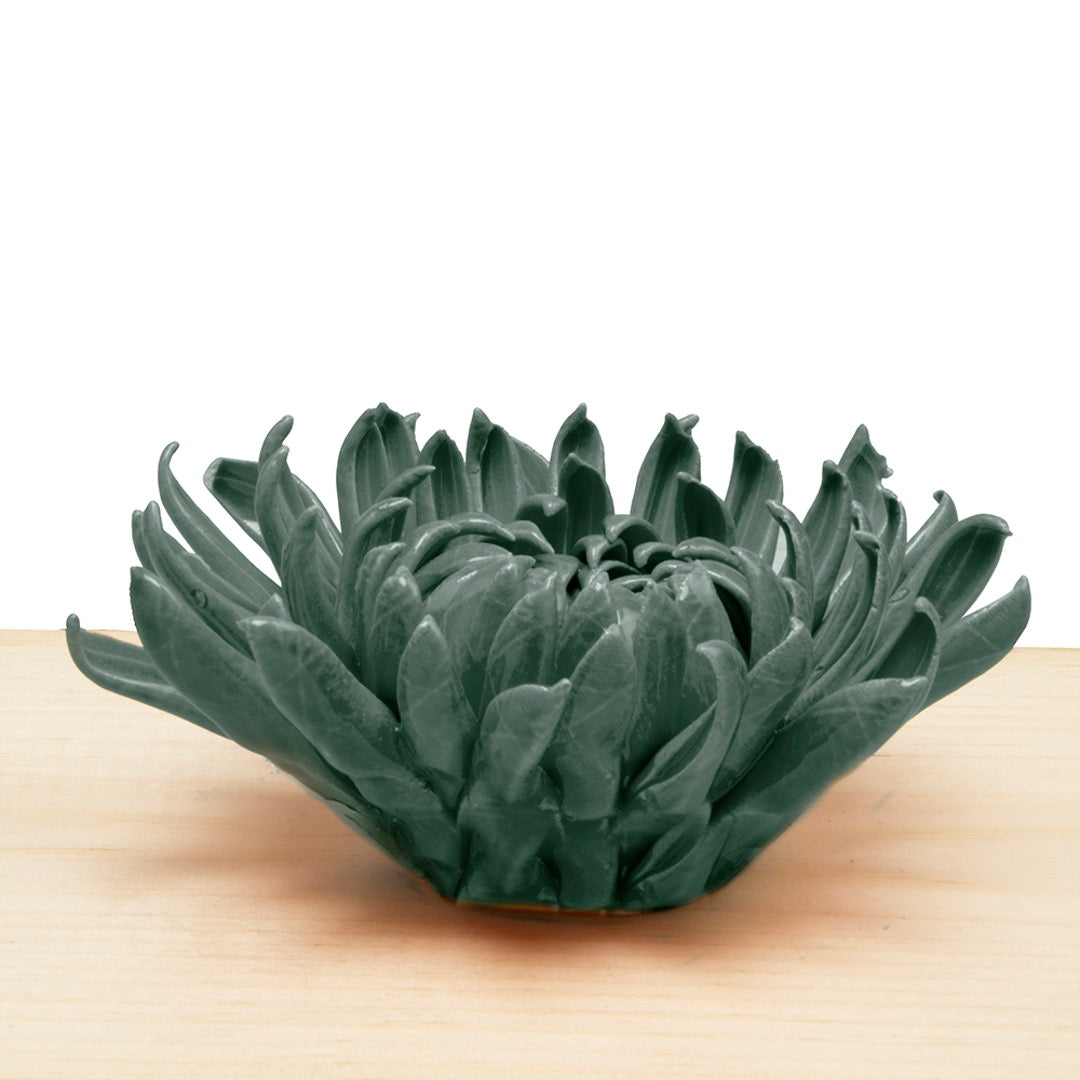 Mum teal coral 4 ceramic chrysanthemum, a layered flower with curling petals in dark teal on a wood surface