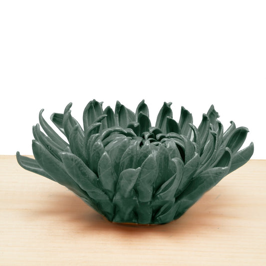 Mum teal coral 4 ceramic chrysanthemum, a layered flower with curling petals in dark teal on a wood surface
