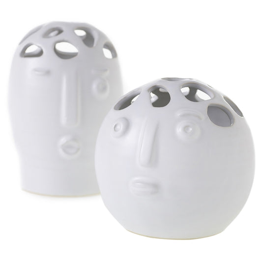 Two matte white Picasso bud vases with sculpted faces and cutout tops, one tall oval and one round