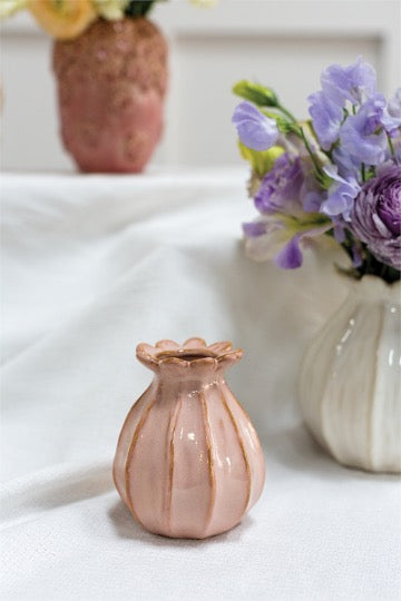 Tulip shaped ceramic budvase  set with violet flowers in background..