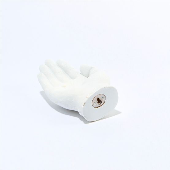 Back of the white Hand Out sculpture showing the round base with a keyhole hanger